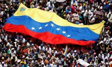 Manifestação nos tempos de Maduro, com grande bandeira do país no centro